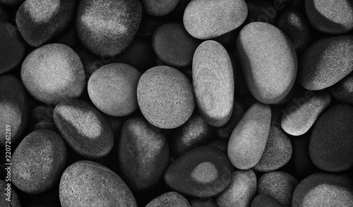 Abstract background textured with smooth, black round, wet pebbles. close-up sea beach with pebbles for website banner template page design.