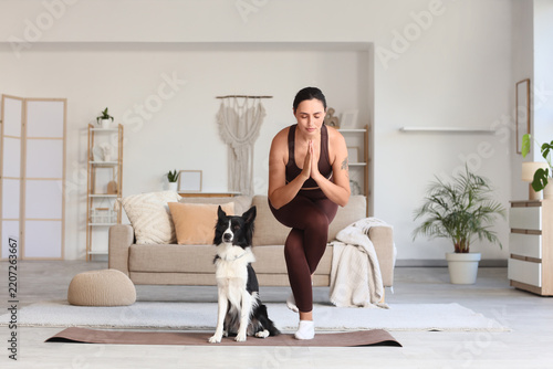 Mindfulness and mental health, woman practicing yoga with her dog at home for...