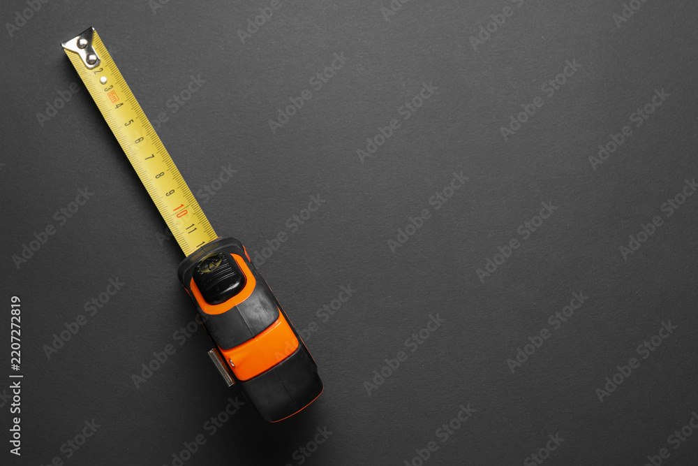 Fototapeta premium Measurement and precision, tape measure on dark background for construction planning and home improvement projects with copy space for text