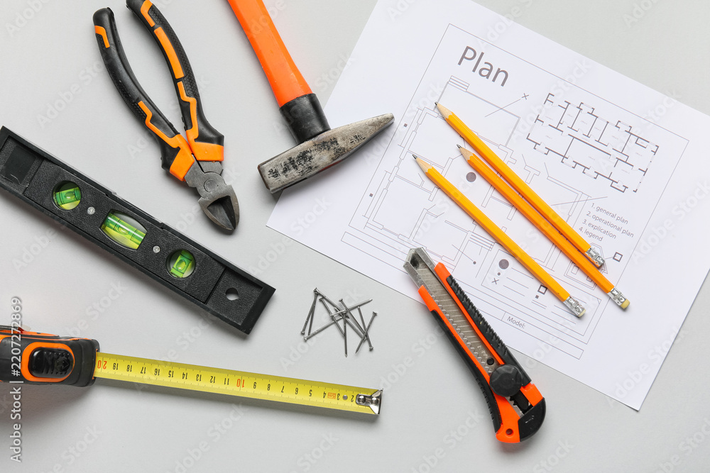 Fototapeta premium Construction planning and home renovation, architectural blueprints with building tools and measuring equipment on a grey background