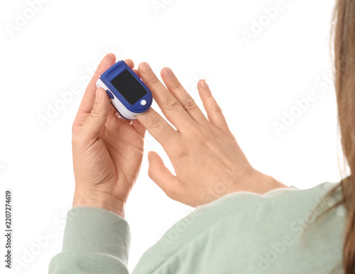 Obraz na plátně Pulse oximetry and health monitoring, person using a finger pulse oximeter to ch
