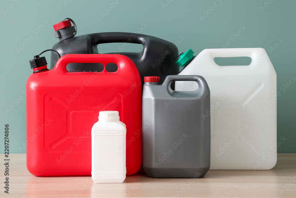 Fototapeta premium Industrial chemical storage and supply chain logistics, plastic jerrycans and containers for hazardous materials and liquid fuel on a wooden table
