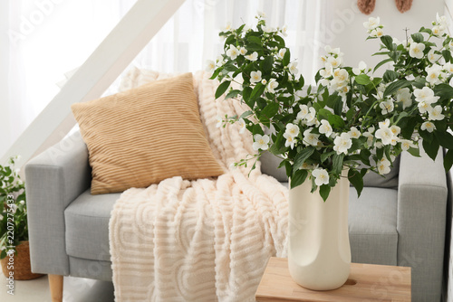 Home interior design and wellness, blooming jasmine flowers in a vase on a wo...