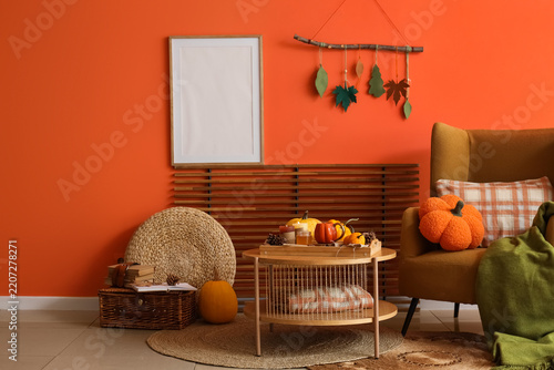 Autumn home interior, cozy fall living room decor with pumpkins and blank pic...
