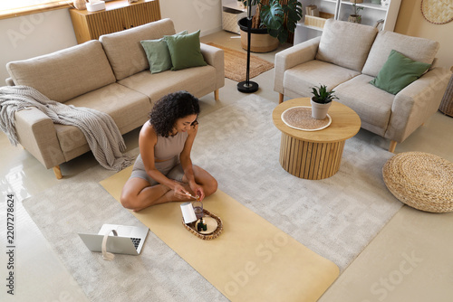 Self care and wellness routine, woman using essential oils and laptop for med...