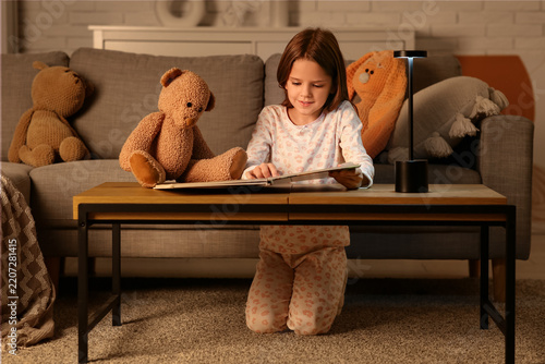 Bedtime reading and childhood development, young girl reading a book with a t...