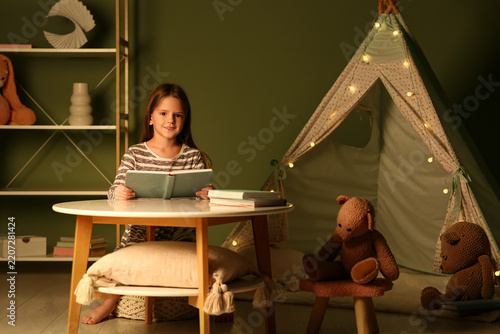 Childhood education and literacy, young girl reading a book in a cozy bedroom...
