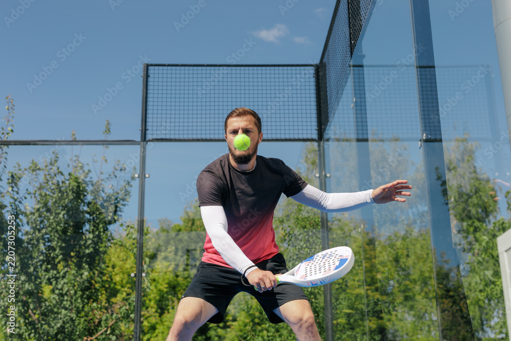 Obraz premium Funny padel player with ball on face during unexpected court reaction