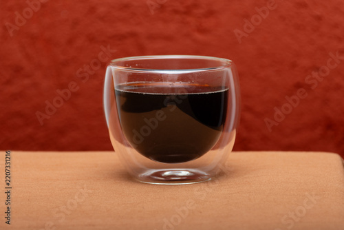 Glass cup with coffee on the table.