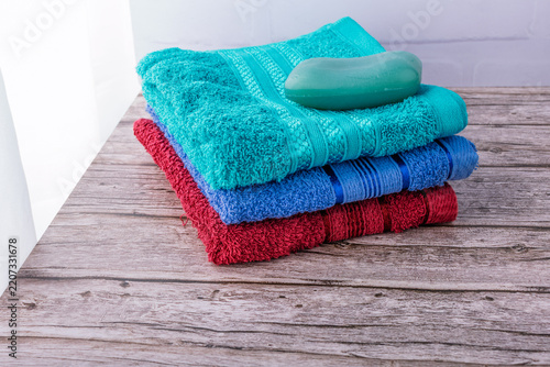 A stack of colorful towels and a bar of soap.