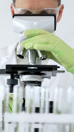 Fotografie Scientist working with microscope, analyzing biological samples in a research la