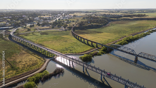 Aerial drone view of the road and rail bridges spanning the Murray River between Murray Bridge East and the agricultural floodplains of Long Flat in South Australia. Regional transport infrastructure.