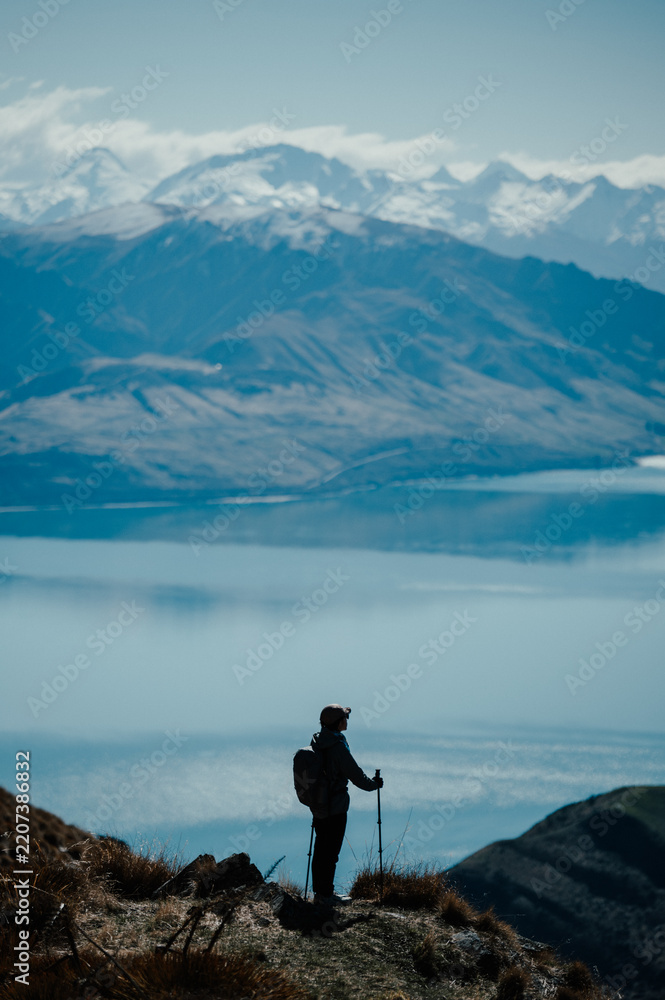 Obraz premium Hiker Descending Mountain Trail with Alpine Scenery in Background