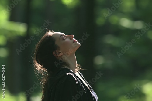 Woman's profile with head tilted back in nature