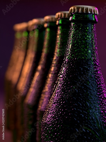 Cold beer bottles with condensation in colorful nightlife lighting