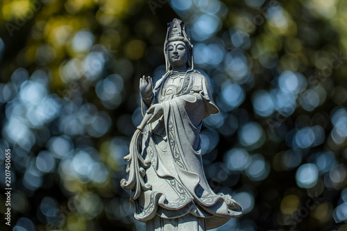 Stone statue of an Asian religious figure against a blurred background