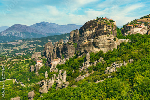 Meteora monastery on a rock formation surrounded by green hills