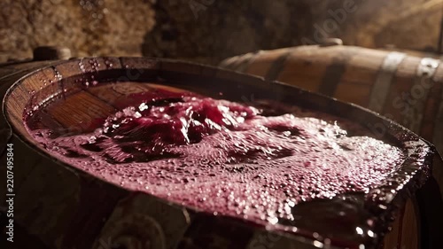 Captivating close-up of vibrant red wine actively fermenting in a rustic oak barrel, showcasing the essential traditional winemaking process and its natural transformation