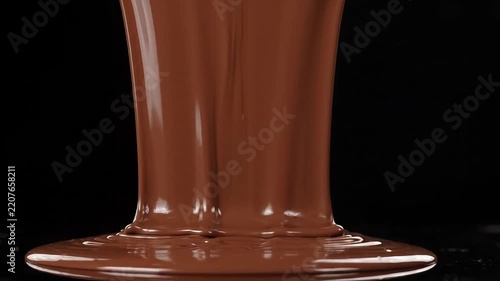 Liquid melted milk chocolate flowing down decadent fountain