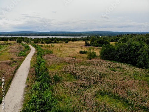 Remote rural path cutting through a broad meadow landscape