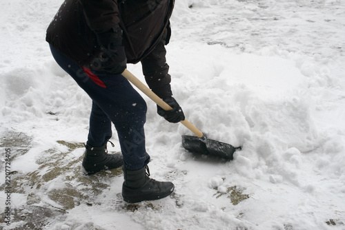 Snow Removal with a Shovel on a Paved Walkway