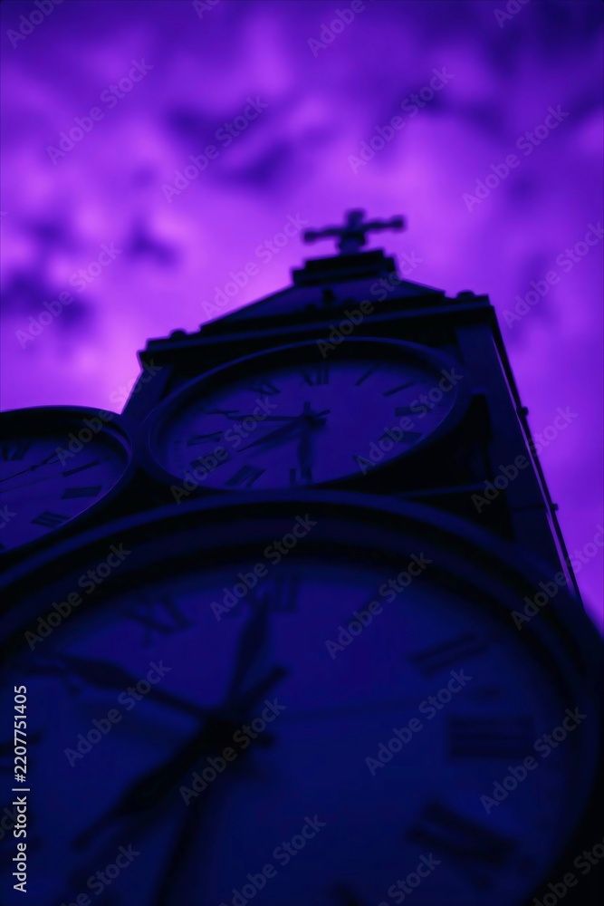 Fototapeta premium Silhouette of a historic clock tower against a dramatic purple twilight sky.