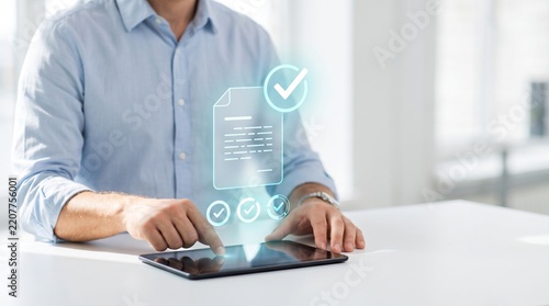 Visualization of Person interacting with a digital document holographic interface displayed above a tablet on a desk with glowing holographic projection finger interact glowing document check marks