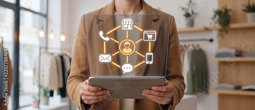 Business person holding tablet with omnichannel retail customer experience and cross-channel marketing network interface in a store