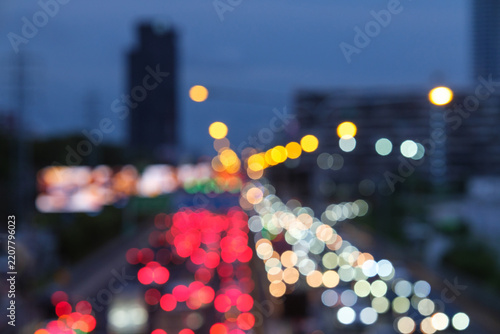 Abstract blurred background traffic jam on expressway in city on evening scene with multicolor bokeh from taillight of vehicle and spotlight 
