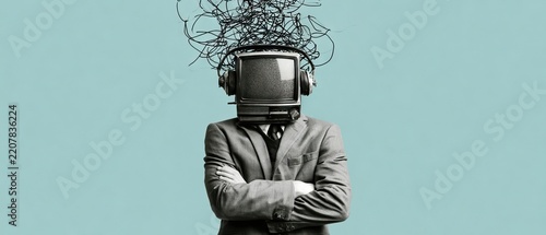 Man in formal suit with vintage television head stands against a light blue grey backdrop with black squiggles around him in a creative artistic scene
