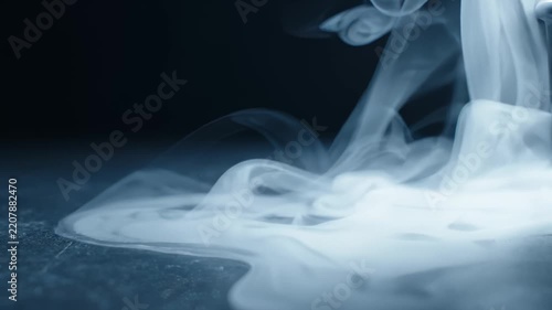 Dense White Smoke Flowing and Swirling Across Dark Surface in Slow Motion