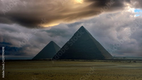 Pirámides de Guiza bajo un cielo dramático al atardecer en Egipto