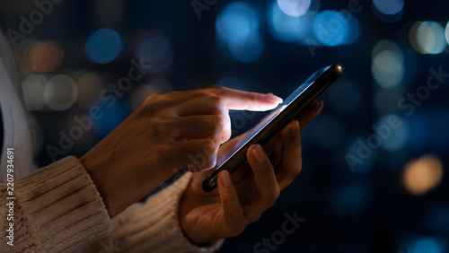 Person using smartphone at night.