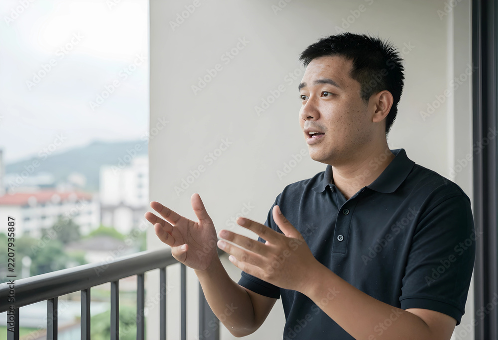 Fototapeta premium Communication and professional consultation, young man explaining ideas with hand gestures on a balcony overlooking an urban city landscape at daytime