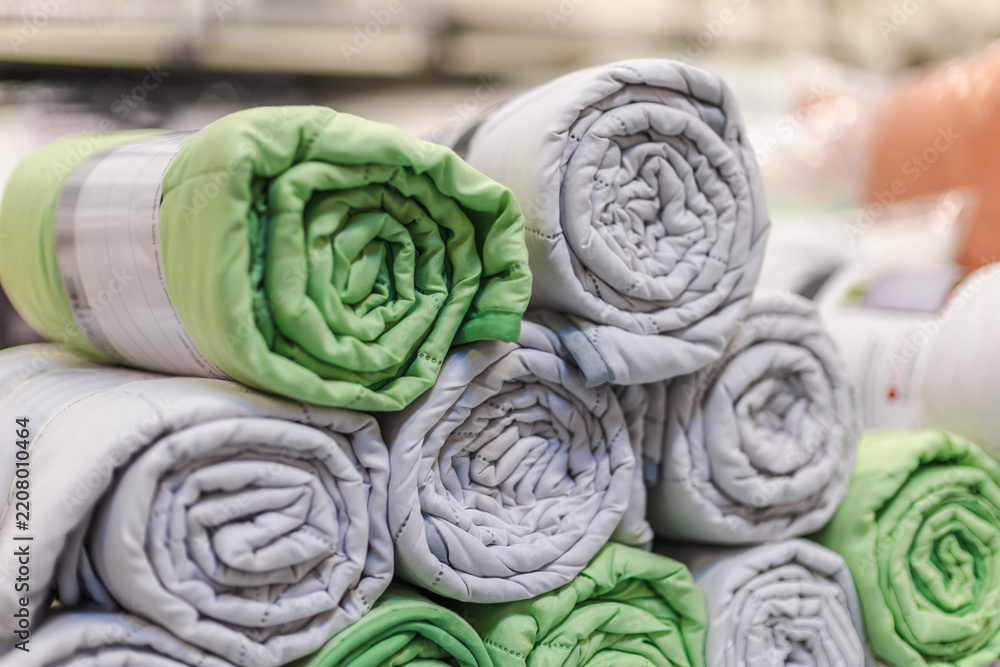 Obraz premium Rolled Green and Gray Padded Textiles in a Home Improvement Store