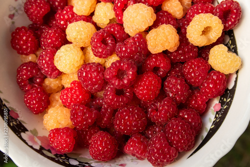 a full bowl of ripe red and yellow raspberries