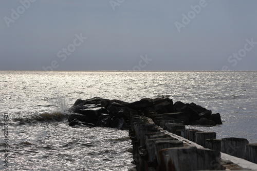 A old nautical looking jetty sitting out on a placid bay during a peaceful summer evening.