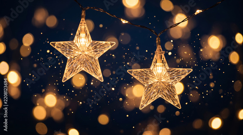 Beautiful illuminated star shaped fairy lights hanging against festive bokeh background