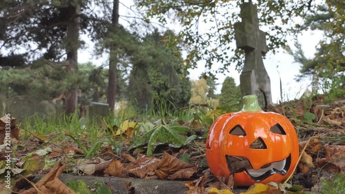 Halloween Pumpkin Lantern Near Gravestone in Cemetery 
