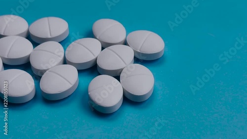 White Medicine Tablets and Pills on Blue Background with Copy Space