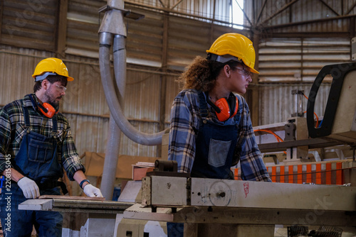 Obraz na plátně Workers using tools in a workshop wearing safety gear and focused on tasks durin