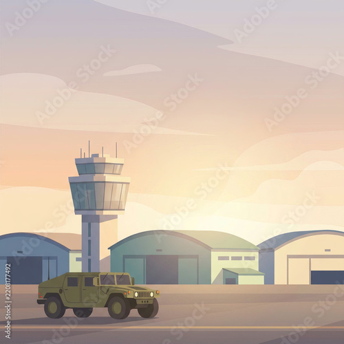 Olive green military vehicle driving past an airfield tower at golden dusk