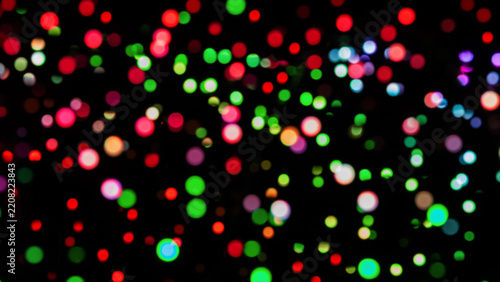 Vibrant multi colored bokeh lights shimmer on a dark background, creating a f...