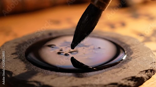 Ink Dripping From Brush Into Stone Circle, Creating Swirling Patterns. Slow Motion Footage of Traditional Calligraphy Process.