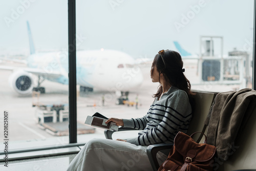 Fotografie Female tourist was annoyed at having to wait for her delayed flight at the airpo