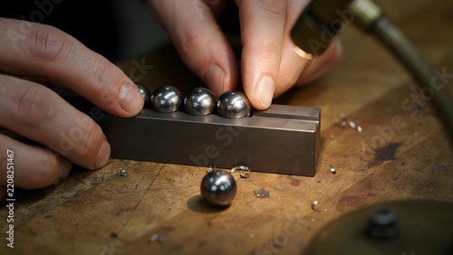 Metal ball manufacturing process involving hand precision machining and polishing on wooden work surface