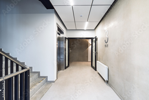 Modern Corridor With Elevator, Staircase and Open Door on Third Floor