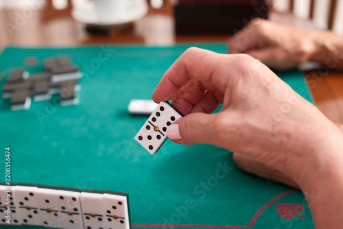 Senior hands playing dominoes during leisure time