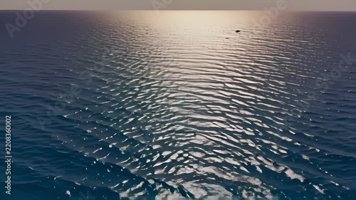 Ocean Waves Rippling with Golden Sunset Reflection on Water Surface