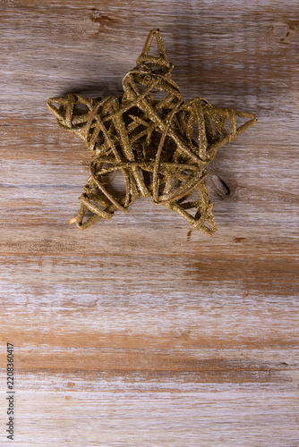 A golden Christmas star against a wooden background
